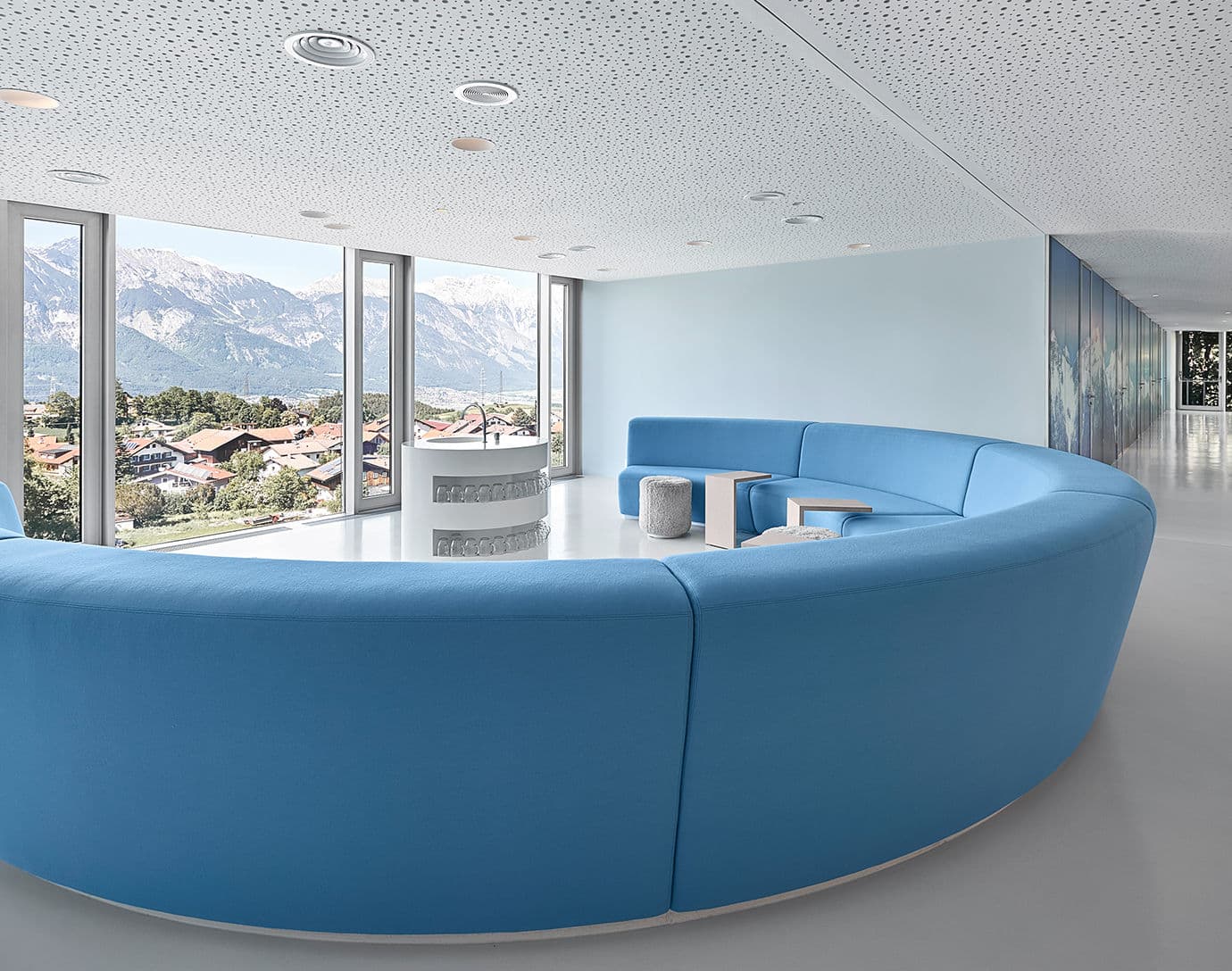 Lanserhof Lans Lounge mit blauem Sofa und Ausblick ins Gruene